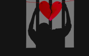 Image of a person holding prison bars with a paper broken heart hanging over them.