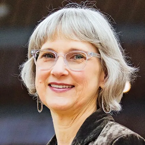 Head shot photograph of Lynda Frost. White woman with short, white hair wearing glasses. HeadshotLyndaFrost
