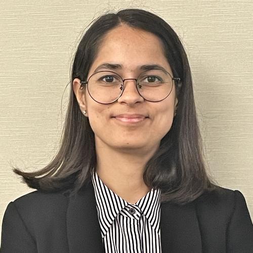 South Asian Woman with short hair and glasses